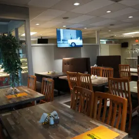 The restaurant has multiple tables and chairs are perfectly arranged for customers with a restaurant menu.